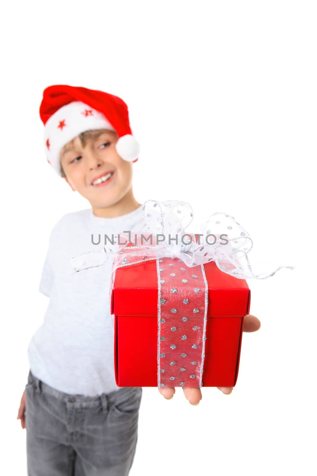 A boy holding a gift and looking sideways at  your text or message.  Focus is the gift.