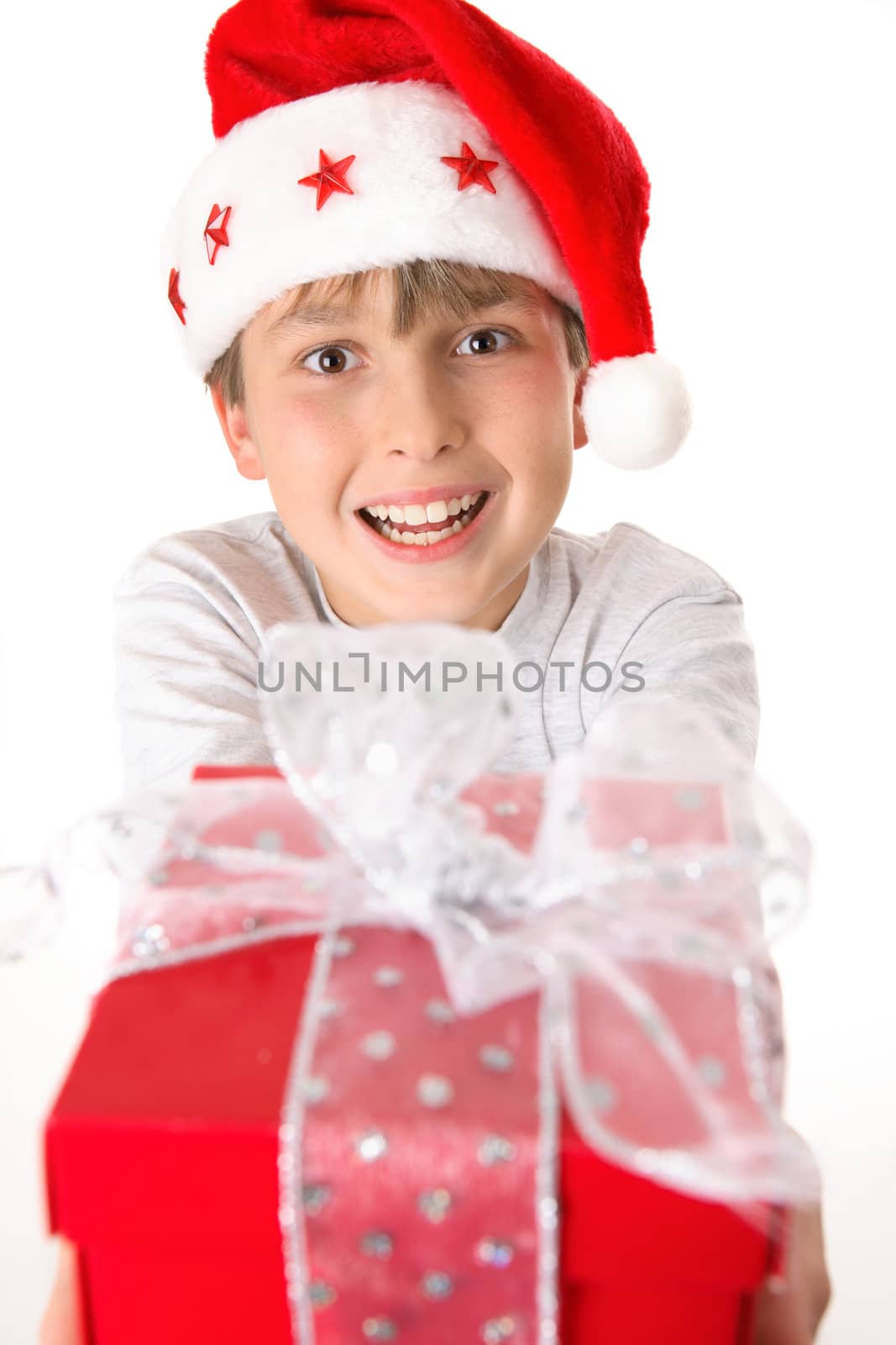 A child holding a bright red gift tied up with silver ribbon.  Focus to boy.