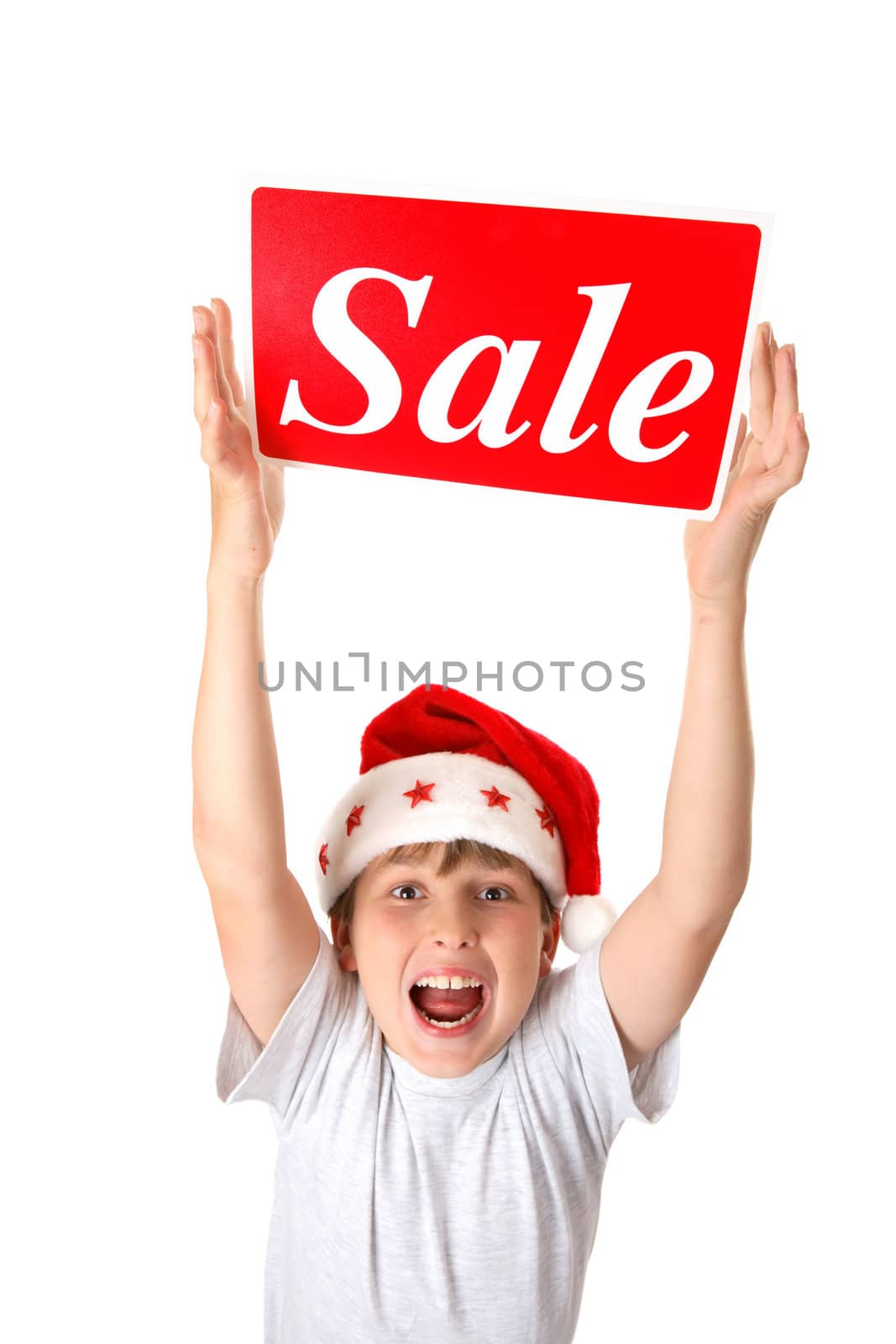 An excited boy holding a sale sign over his head, suitable for pre or post Christmas sales.
