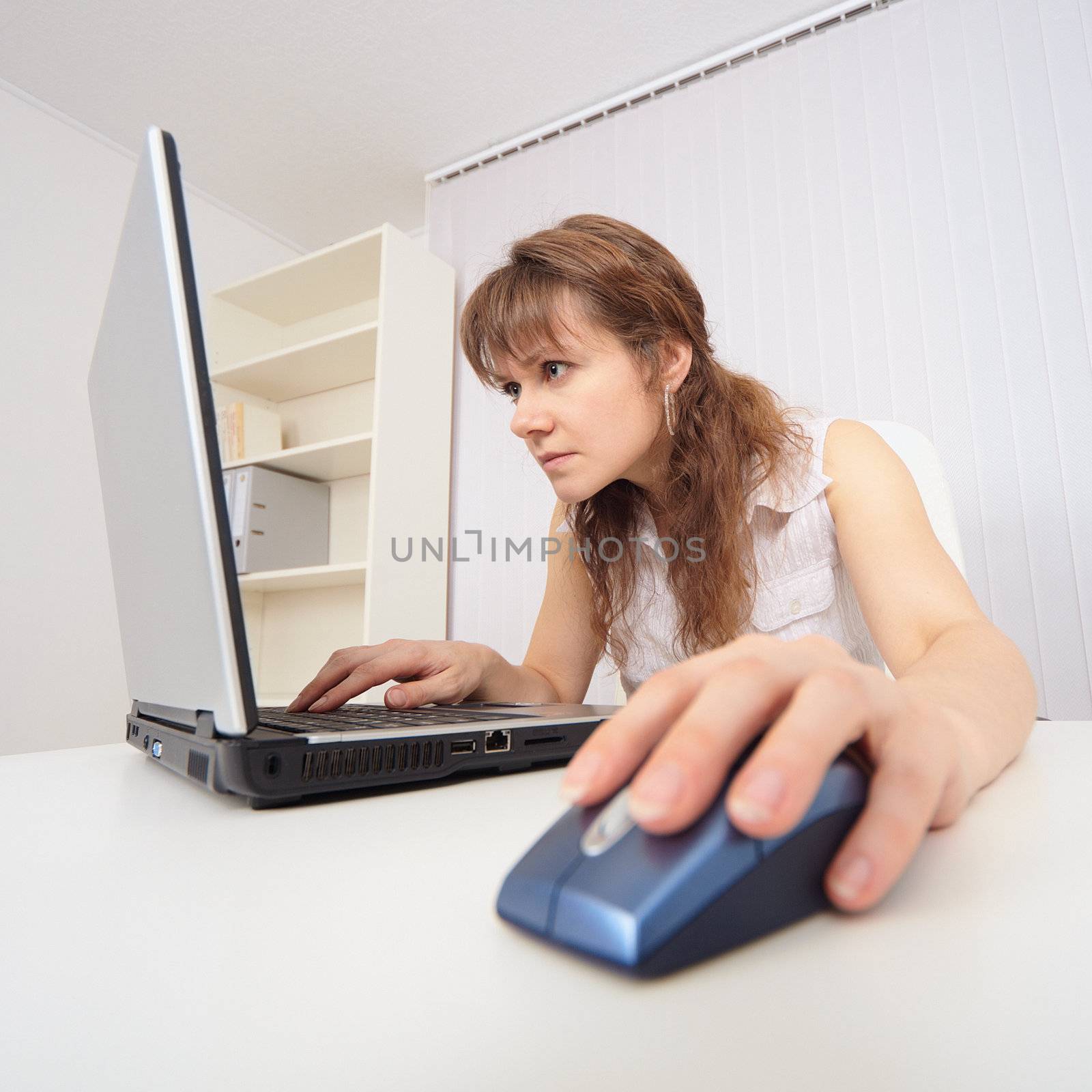 The young woman with concentration works in the Internet on the computer