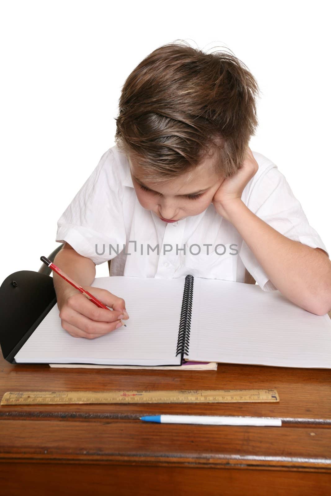 A school pupil sitting at desk doing classwork or homework.