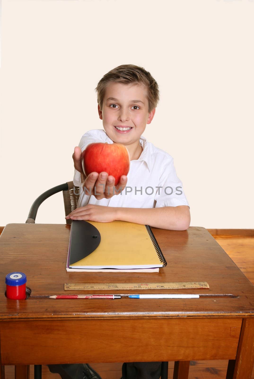 A happy schoolboy giving teacher an apple.