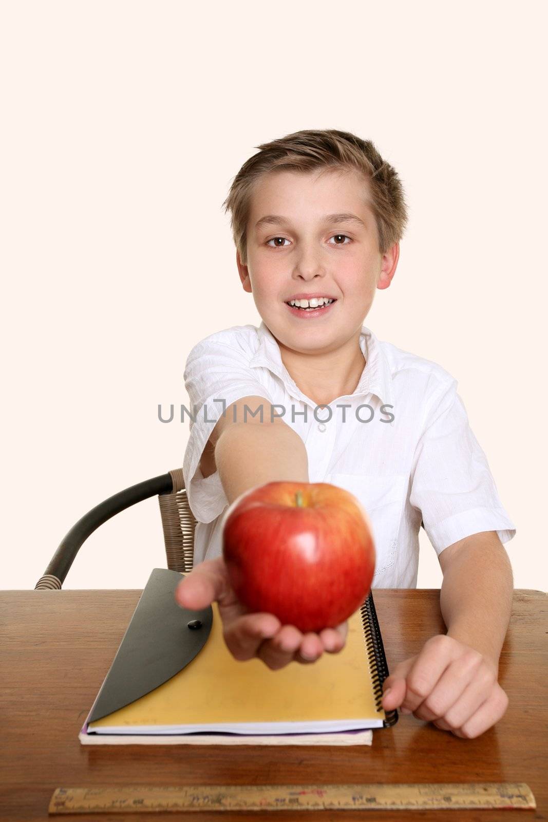 A child holds out an apple for his teacher.