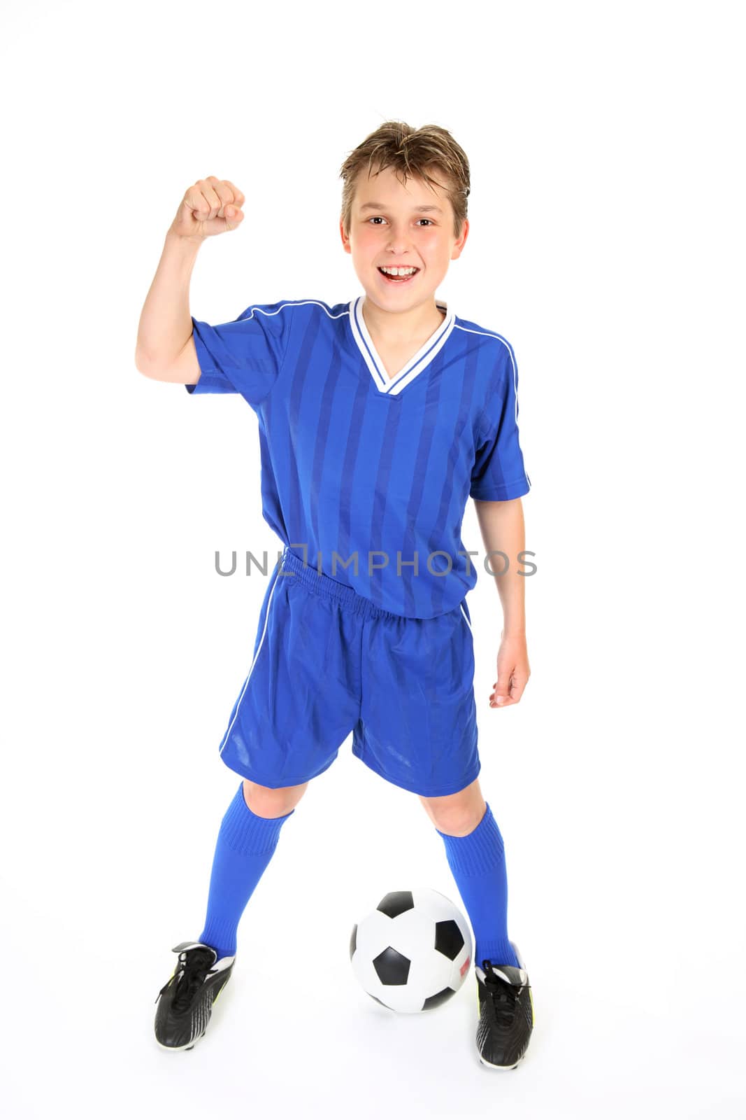 A boy in soccer jersey and shorts with fists in victory