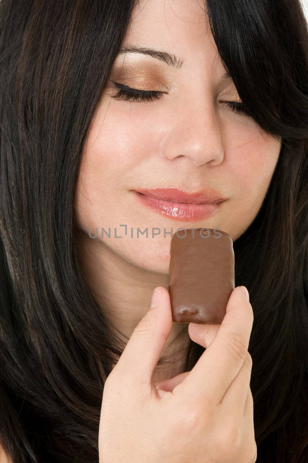 Woman holding a piece of chocolate confection.