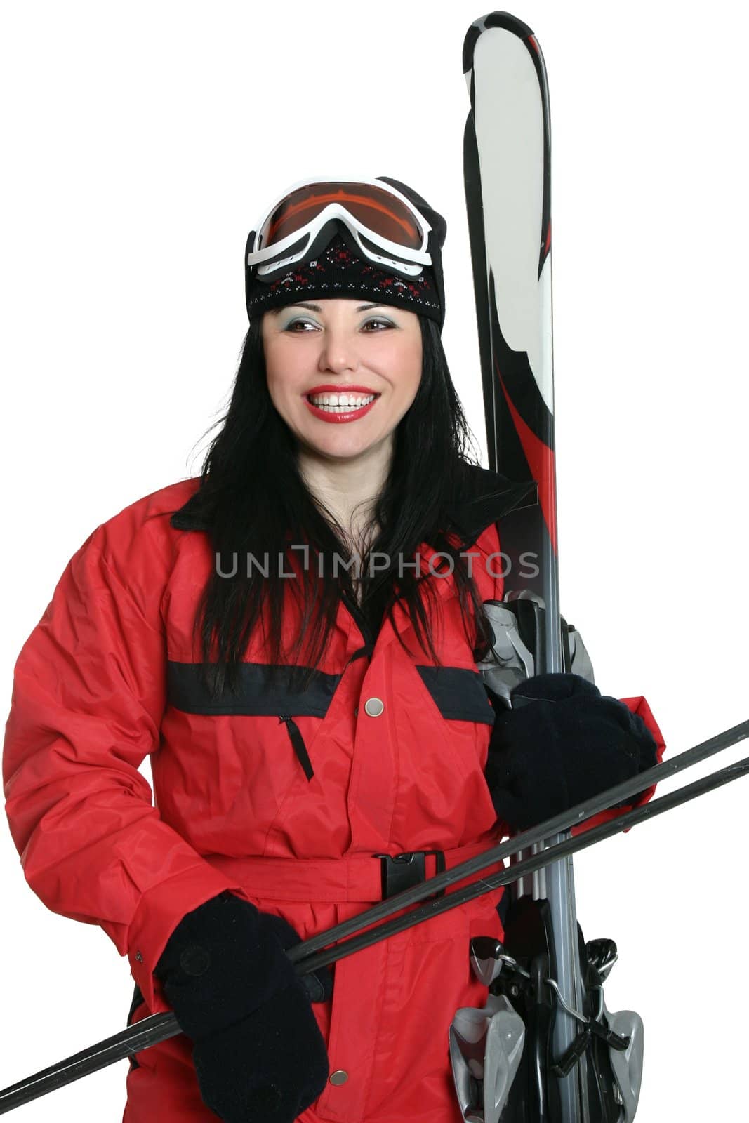 A woman dressed in ski suit and carrying gear for skiing.