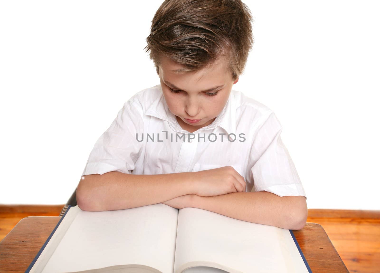 School student at desk reading or studying diligently.