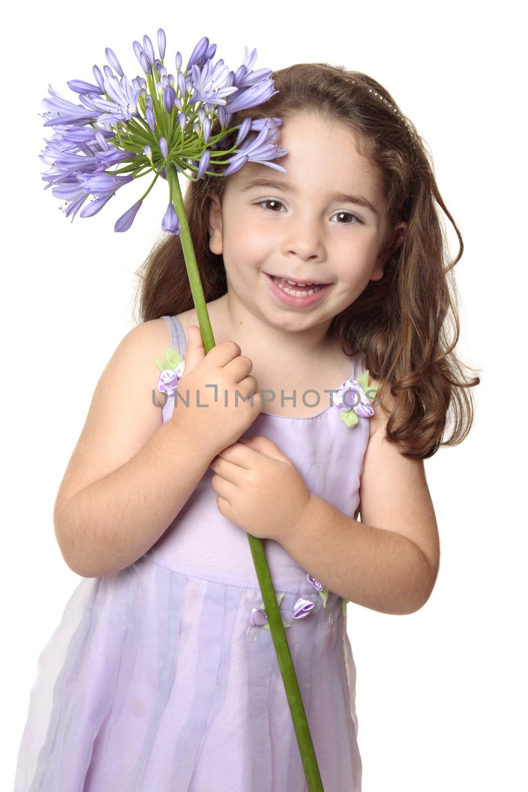 Pretty girl dressed in a beautiful mauve dress is holding a large agapanthus flower and smiling with pure joy.