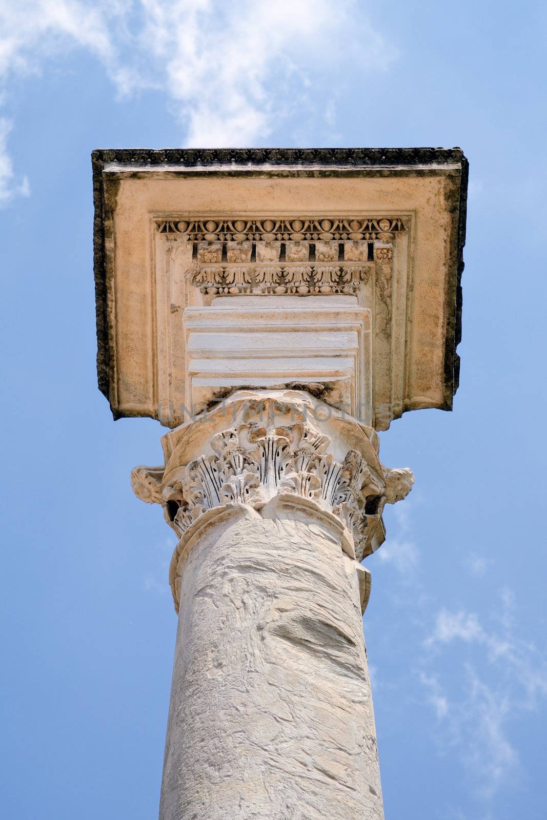 Ancient marble column against the blue sky. Rome, Italy