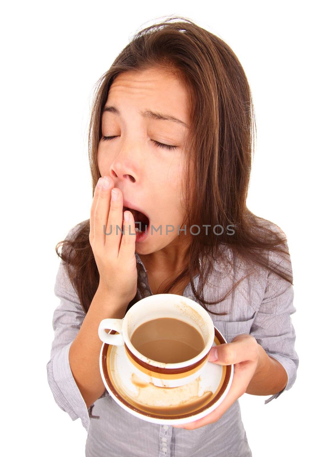 Tired woman yawning spilled a little coffe. Beautiful mixed race asian / caucasian model isolated on white background.