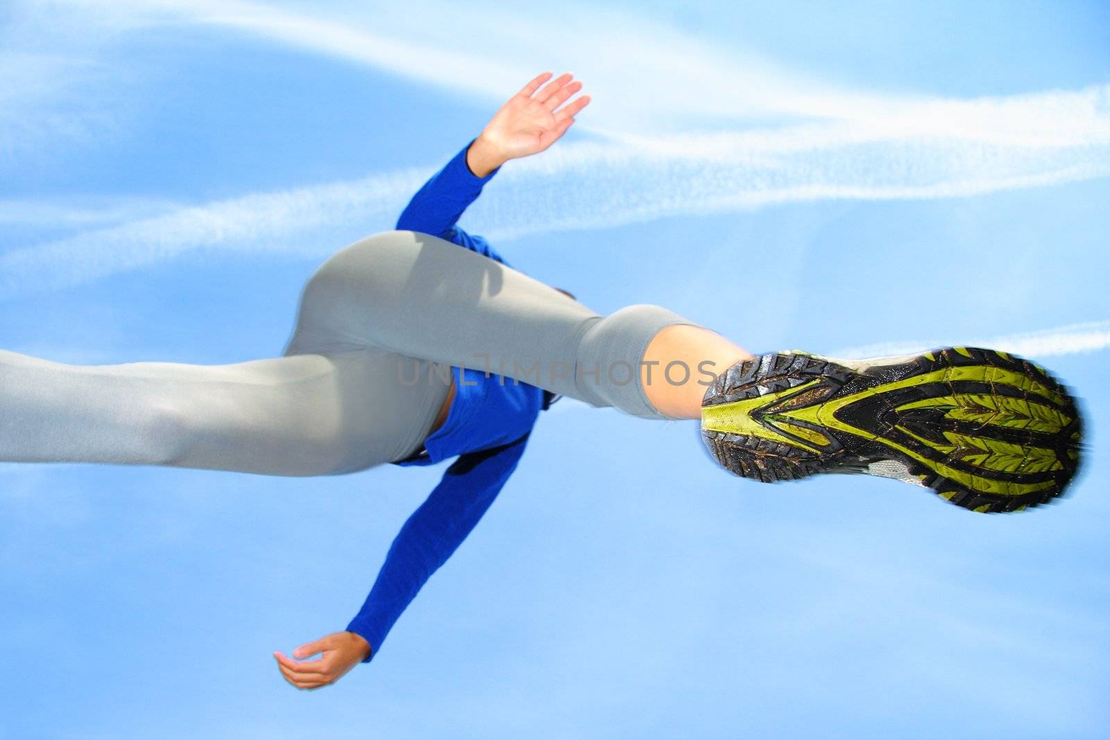 Running and jumping over the camera. Speed and action composition. Shallow depth of field, focus on the female running shoe.