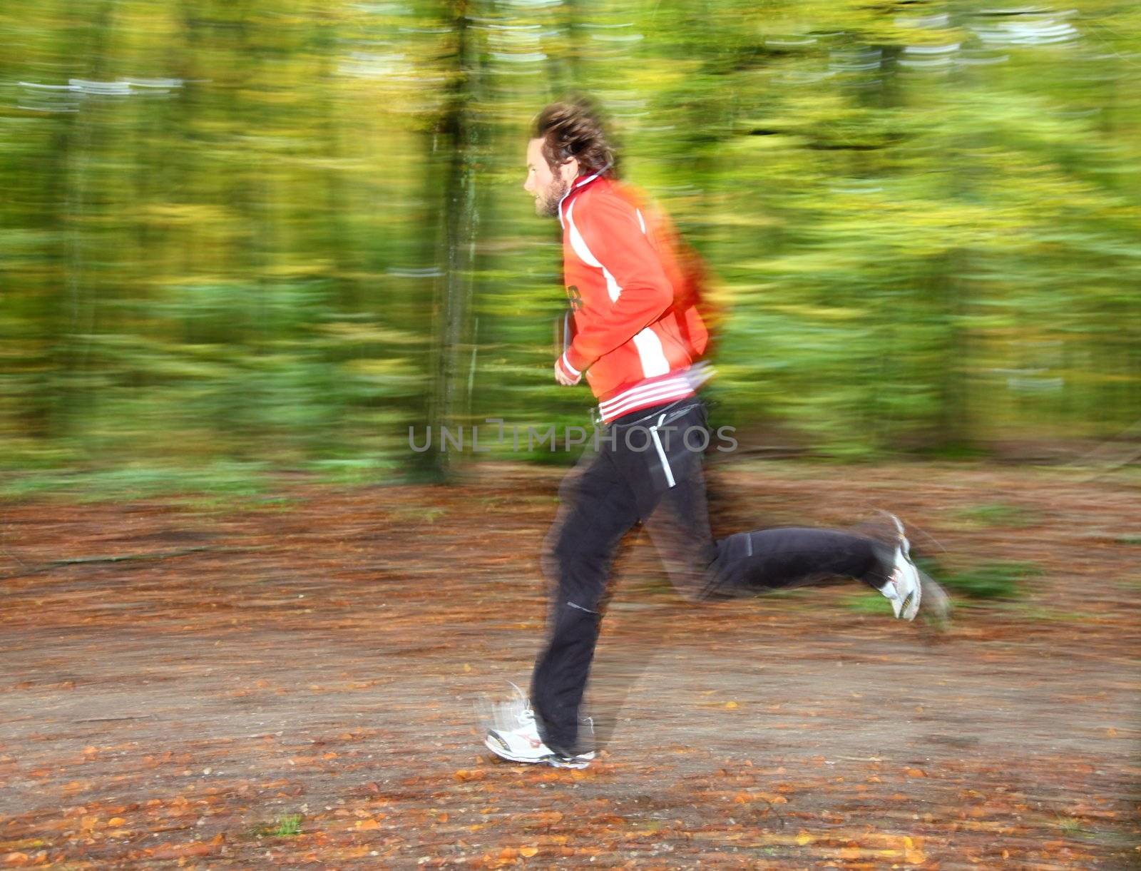 Man running in forest. Motion blurred.