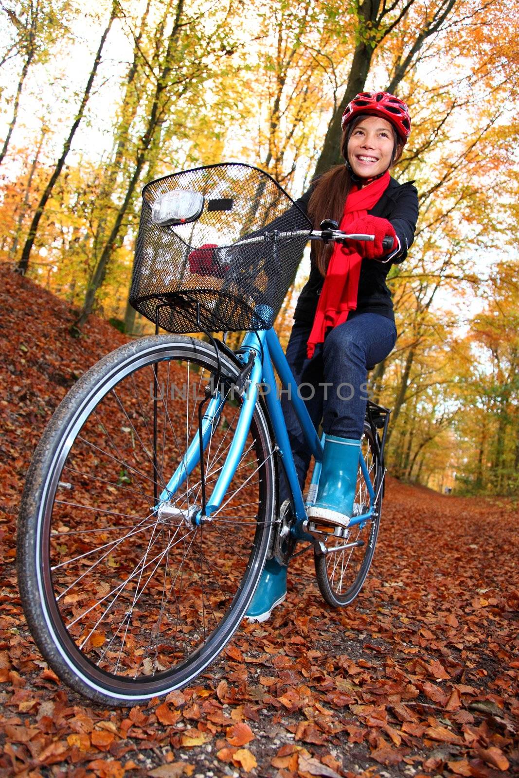 Biking, Woman on bike in autumn forest. Beautiful mixed asian / caucasian model.