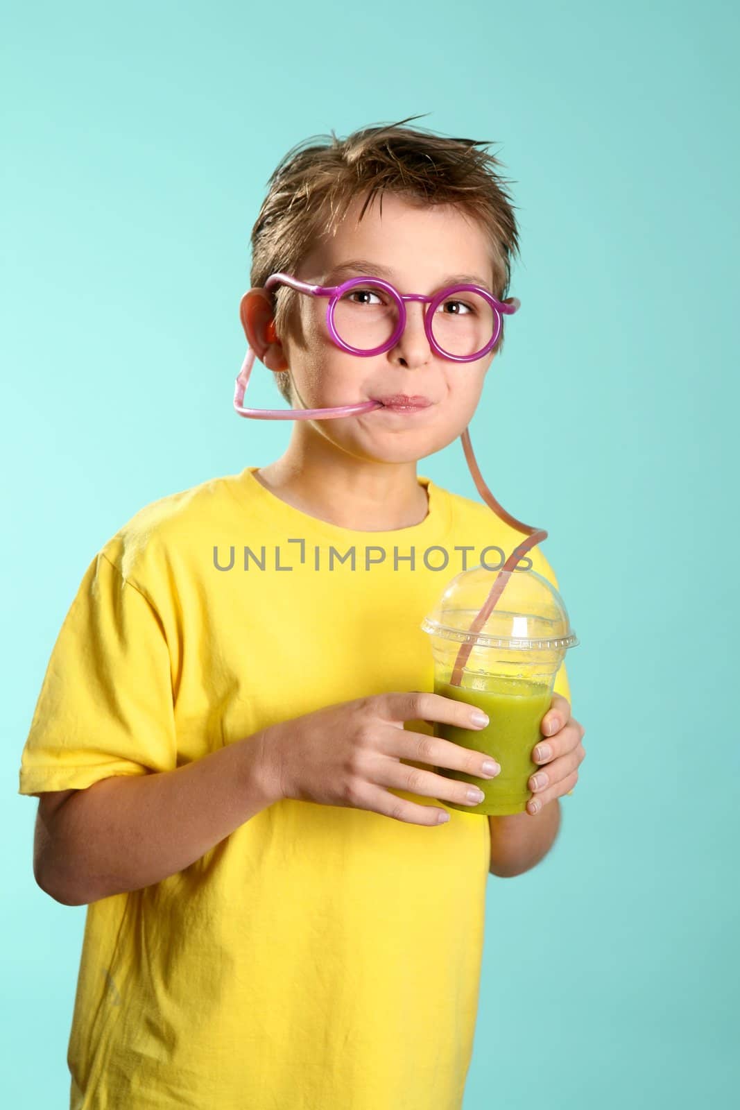 A boy sips a health juice containing nourishing wheatgrass, barleygrass and spirulina 
through a crazy sipper straw