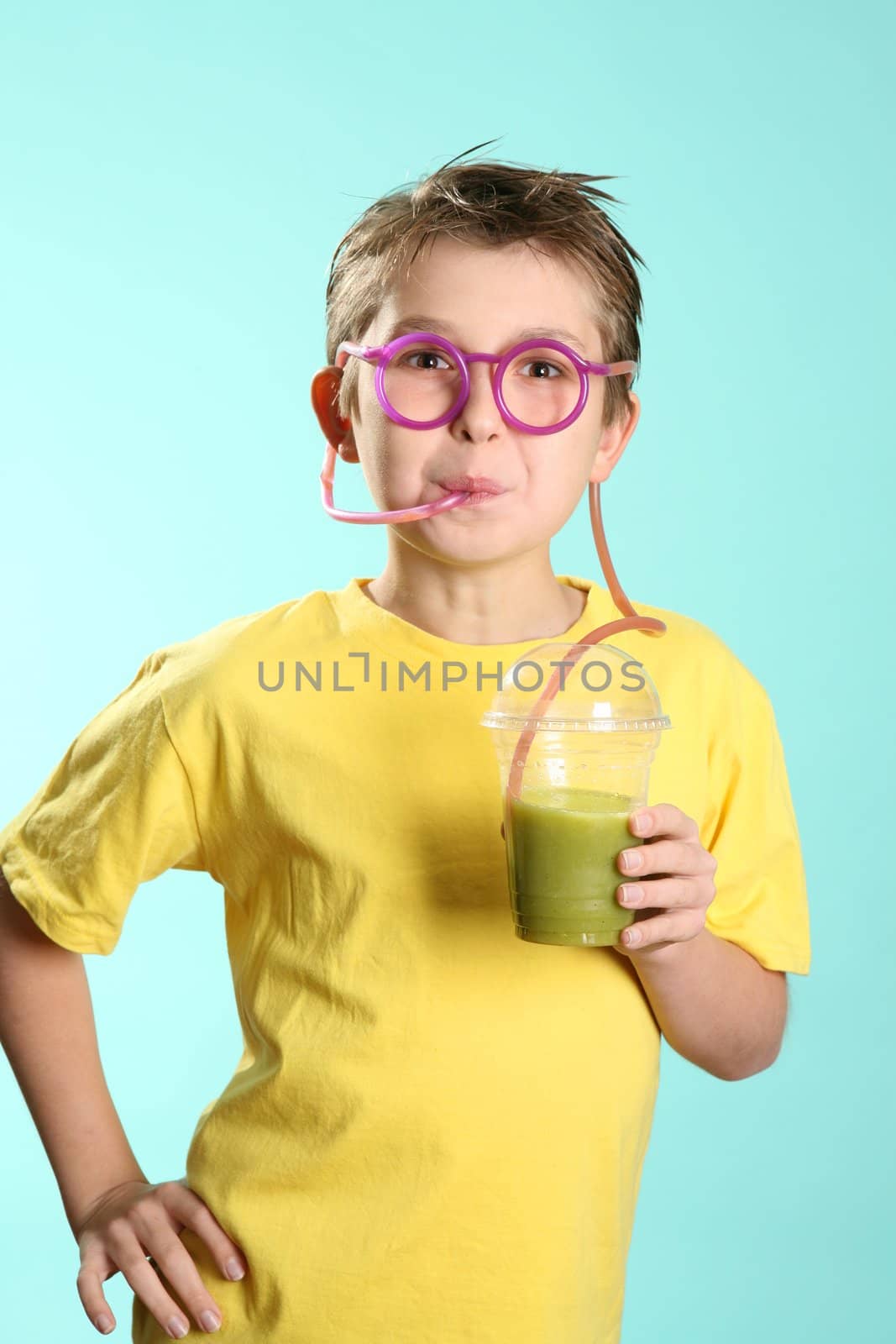 A boy sips a healthy juice containing wheat and barley grass through a crazy straw.
Wheatgrass in juice has been proven over many years to benefit people in numerous ways: cleansing the lymph system, building blood,  removing toxic metals from the cells, nourishing the liver and kidneys and restoring vitality.