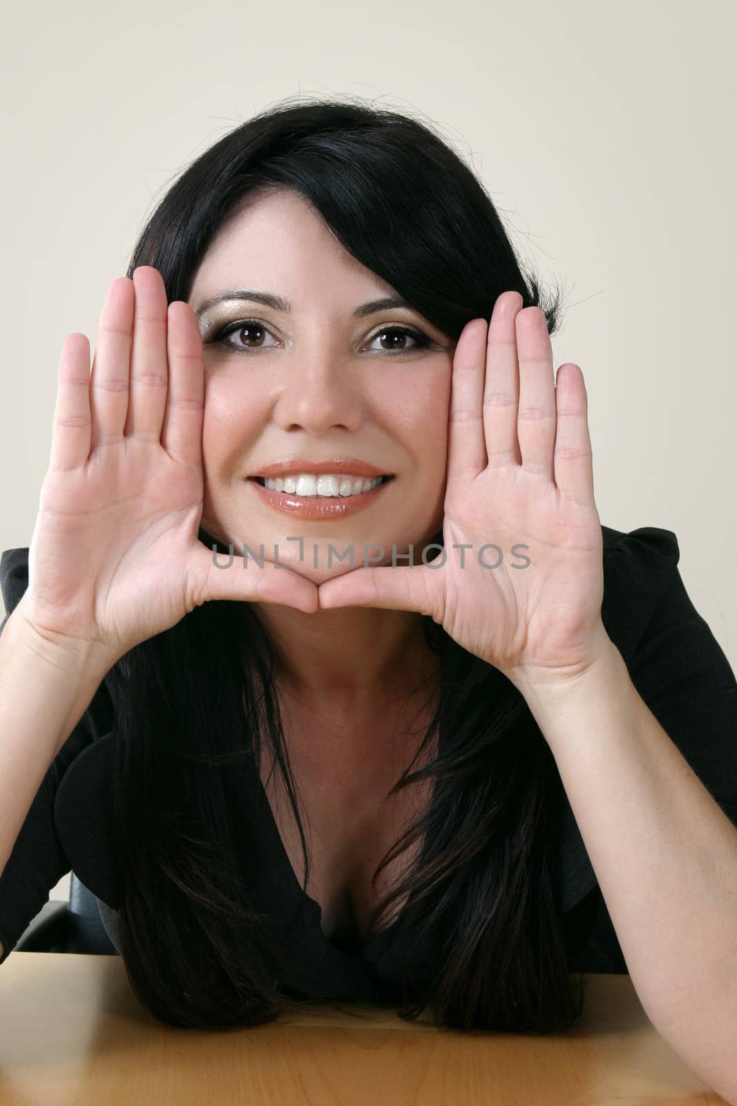 Businesswoman with hands framing face.