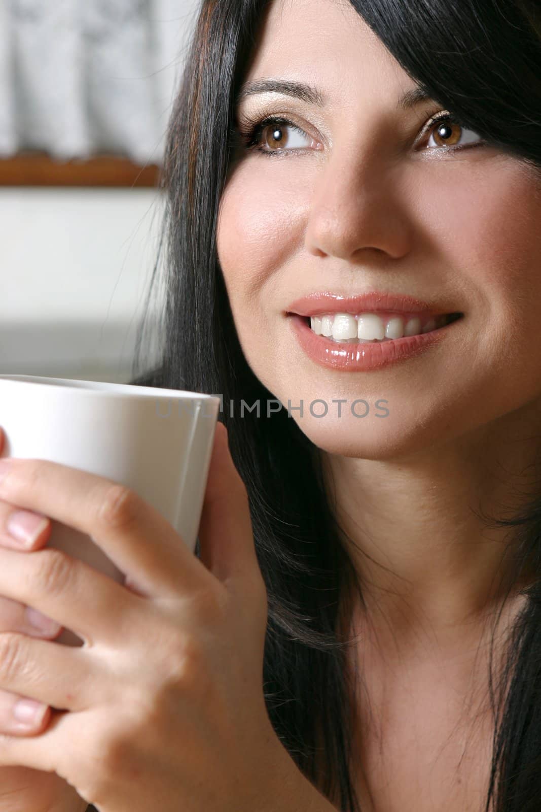 A woman leisurely relaxes with a hot beverage.