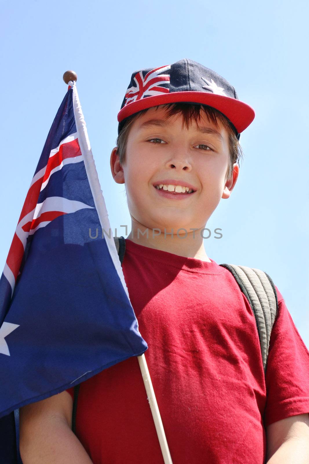 Smiling young boy outdoors holding a flag