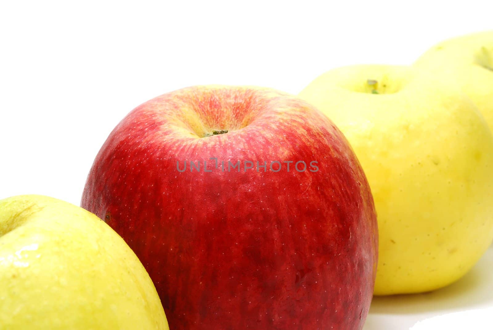 Red Leader Apple between Yellow Apples Isolated on White