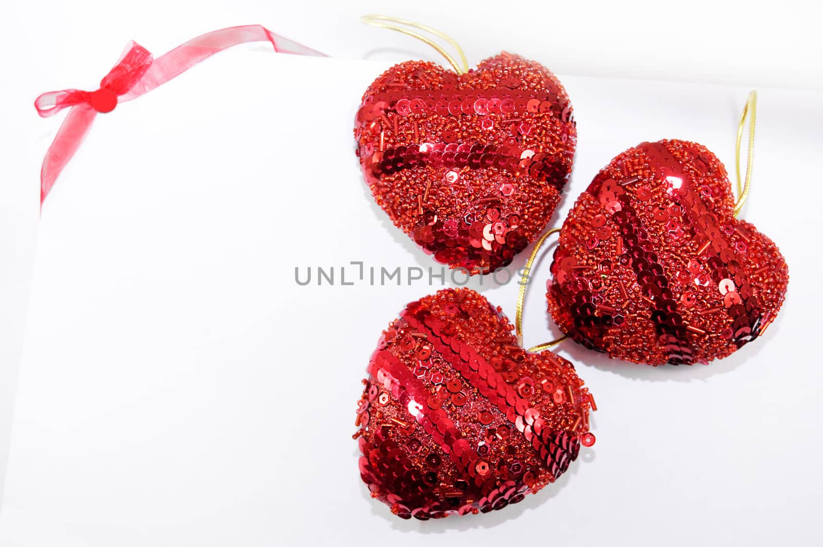 Red hearts and ribbon on white background, may be used as greeting card