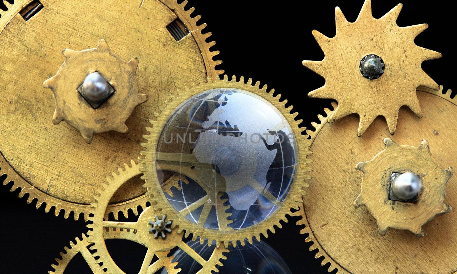 Closeup of glass globe and old clock mechanism on dark background