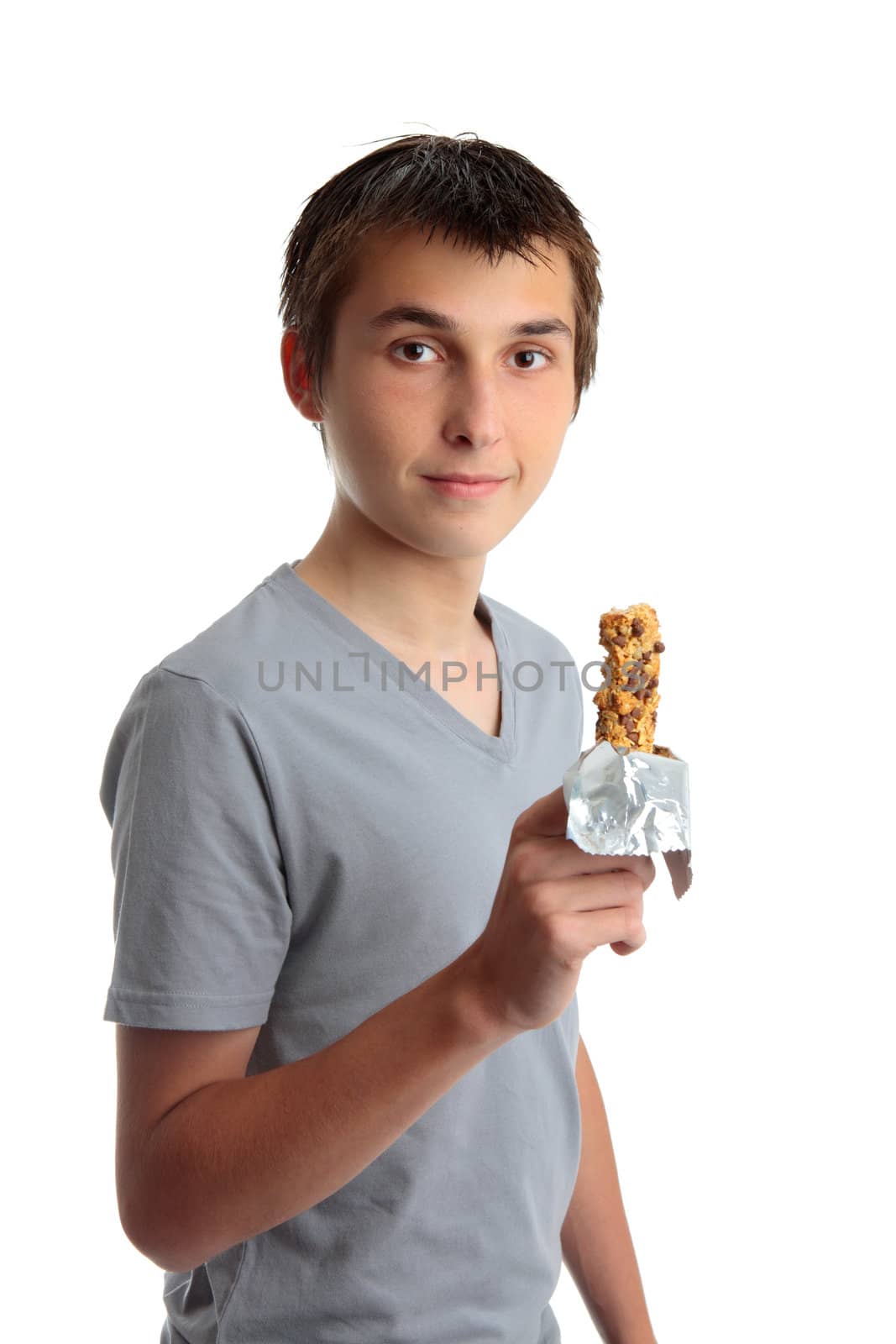 A young teen boy holding a nutritional cereal snack bar.