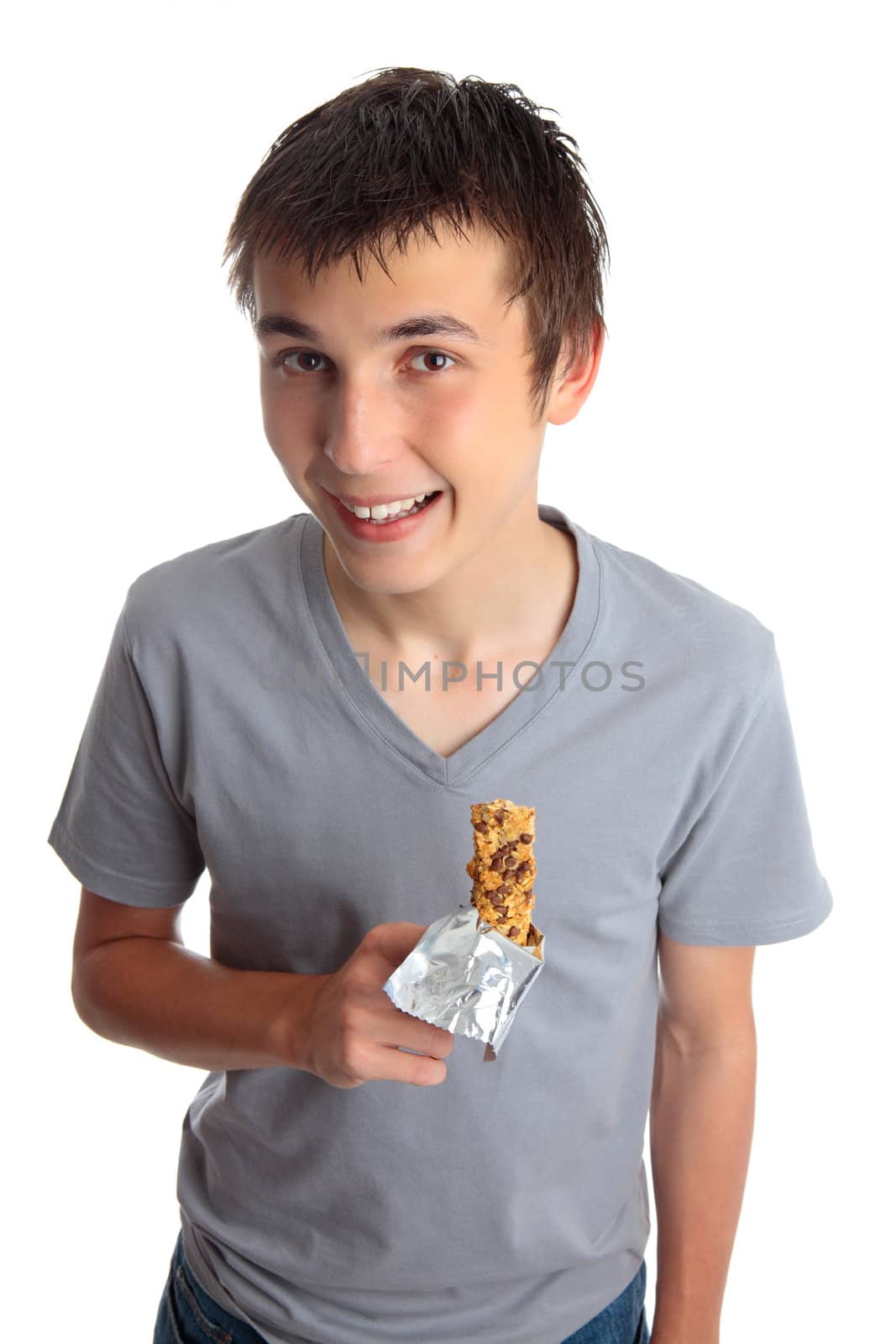 A smiling boy holding a healthy muesli bar snack.
