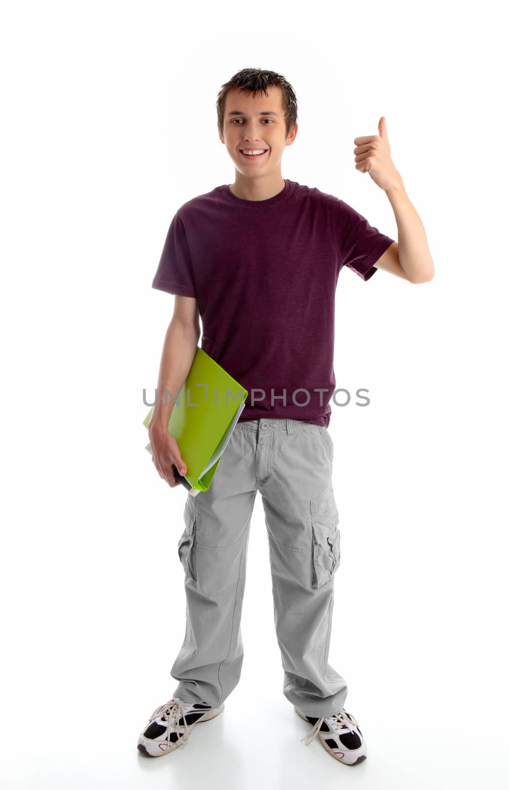 A happy male teen dressed in cargoes and maroon marle t-shirt, is carrying a lime green folder in one hand and showing thumbs up success or approval hand sign in the other.  White background.