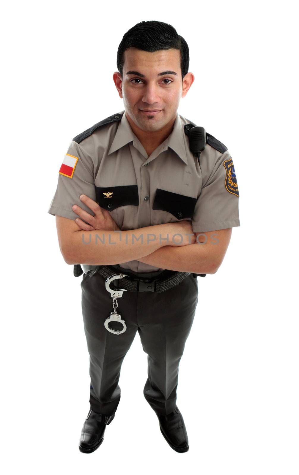 A male prison guard warden or policeman in uniform with duty belt and radio unit.   Standing with arms crossed and looking up.  White background