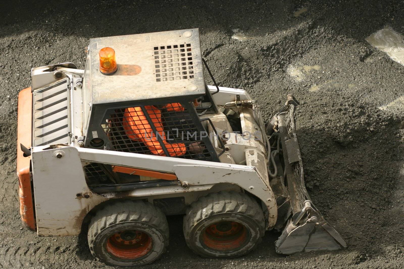 Bobcat scooping up gravel
