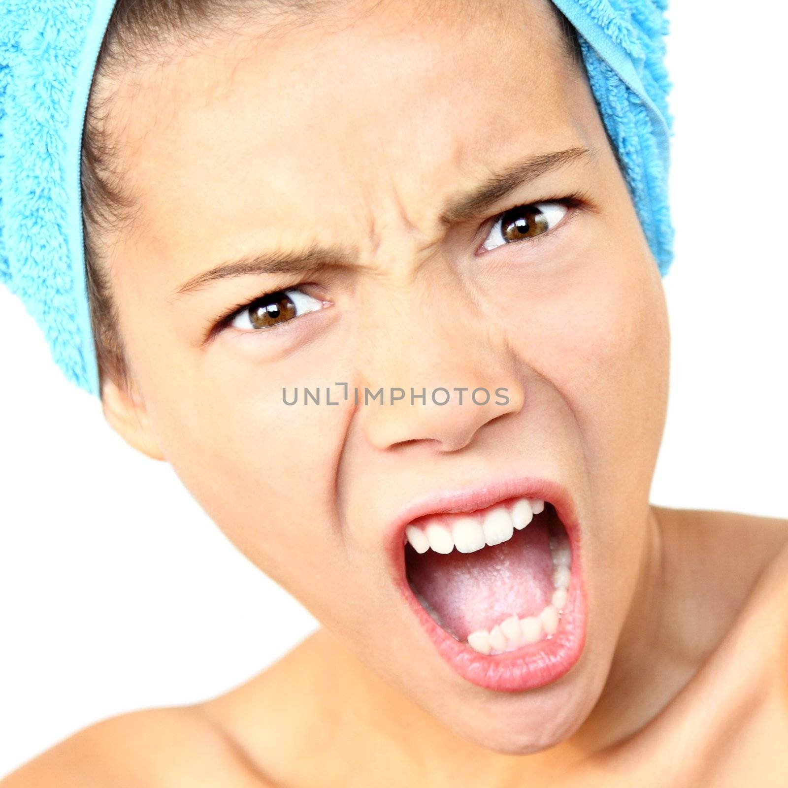 Angry and surprised woman shocked with towel around her head - just out of the shower. Beautiful young woman model. Isolated on white background.