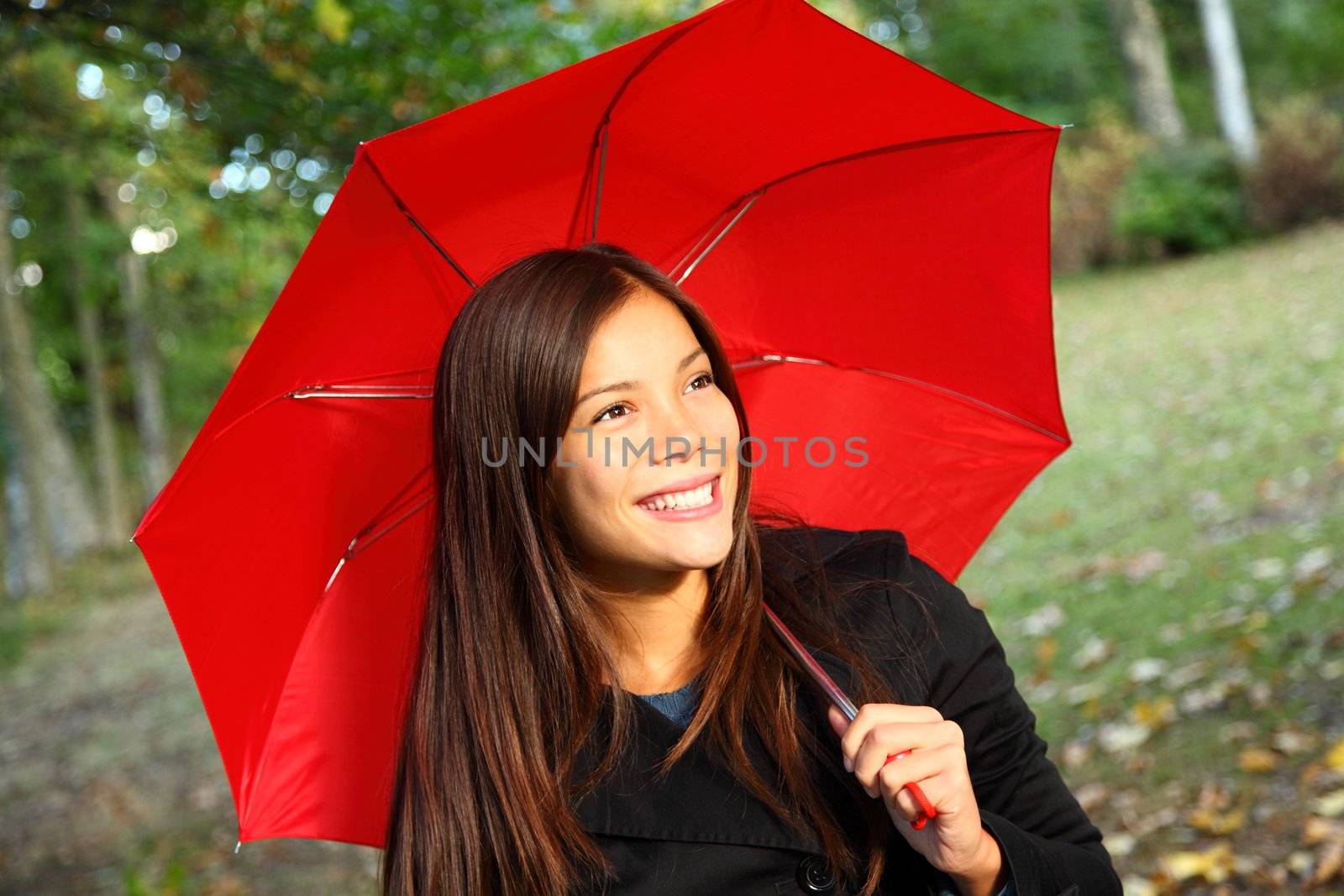 Red umbrella woman outdoors in autumn forest. Beautiful model.