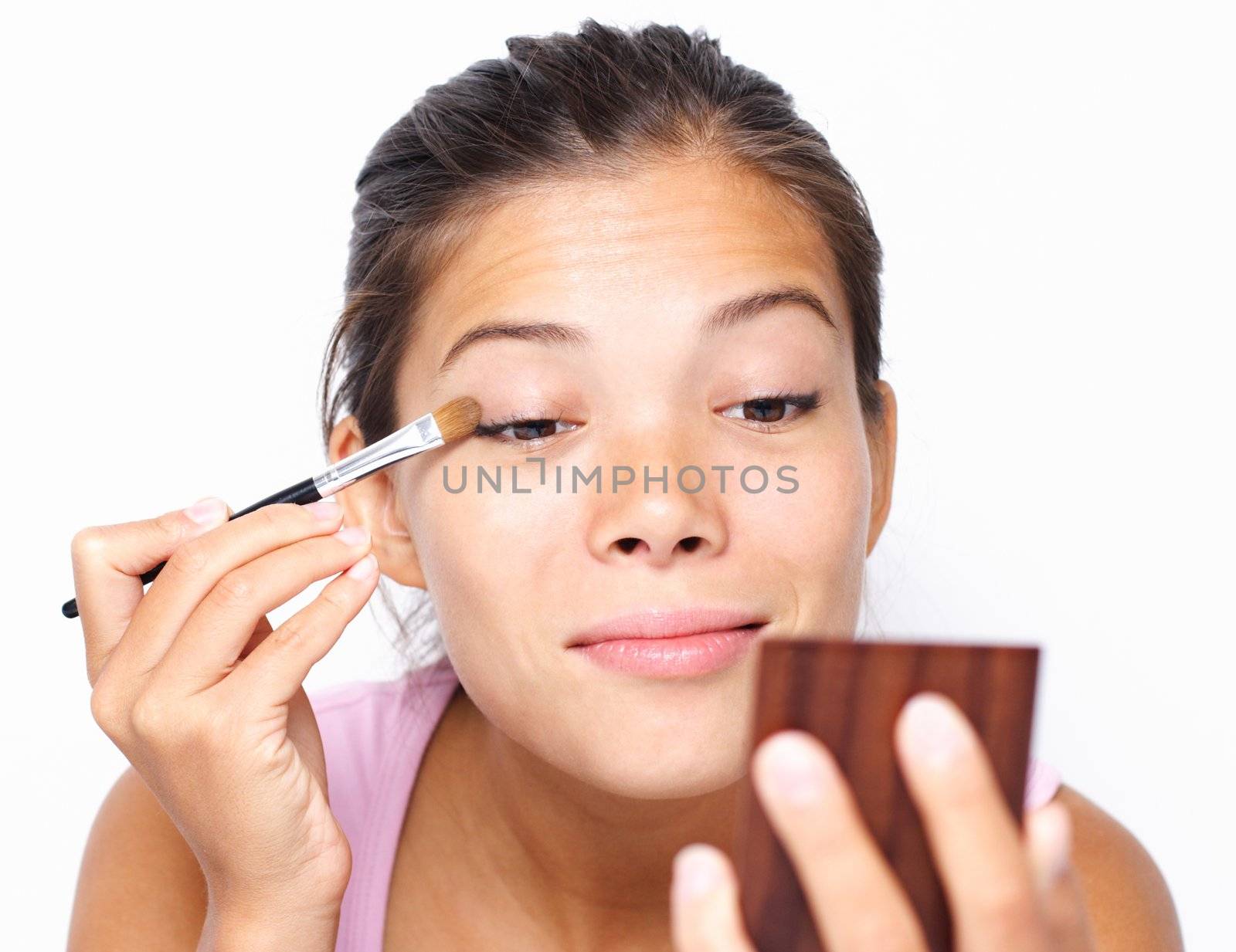 Beautiful mixed asian / caucasian woman putting makeup.