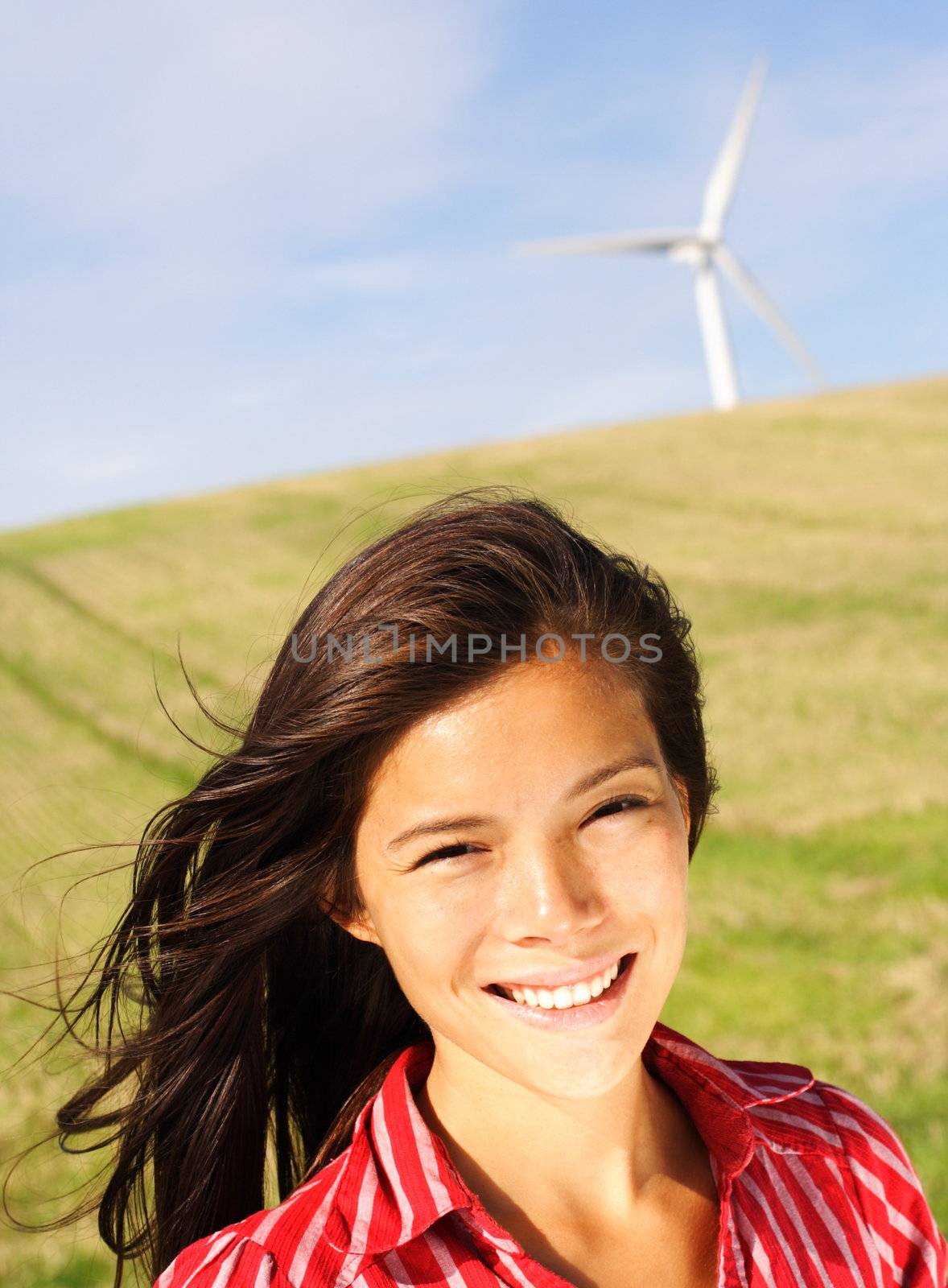 Wind turbine. Beautiful mixed race chinese / caucasian woman by wind turbine in Denmark.