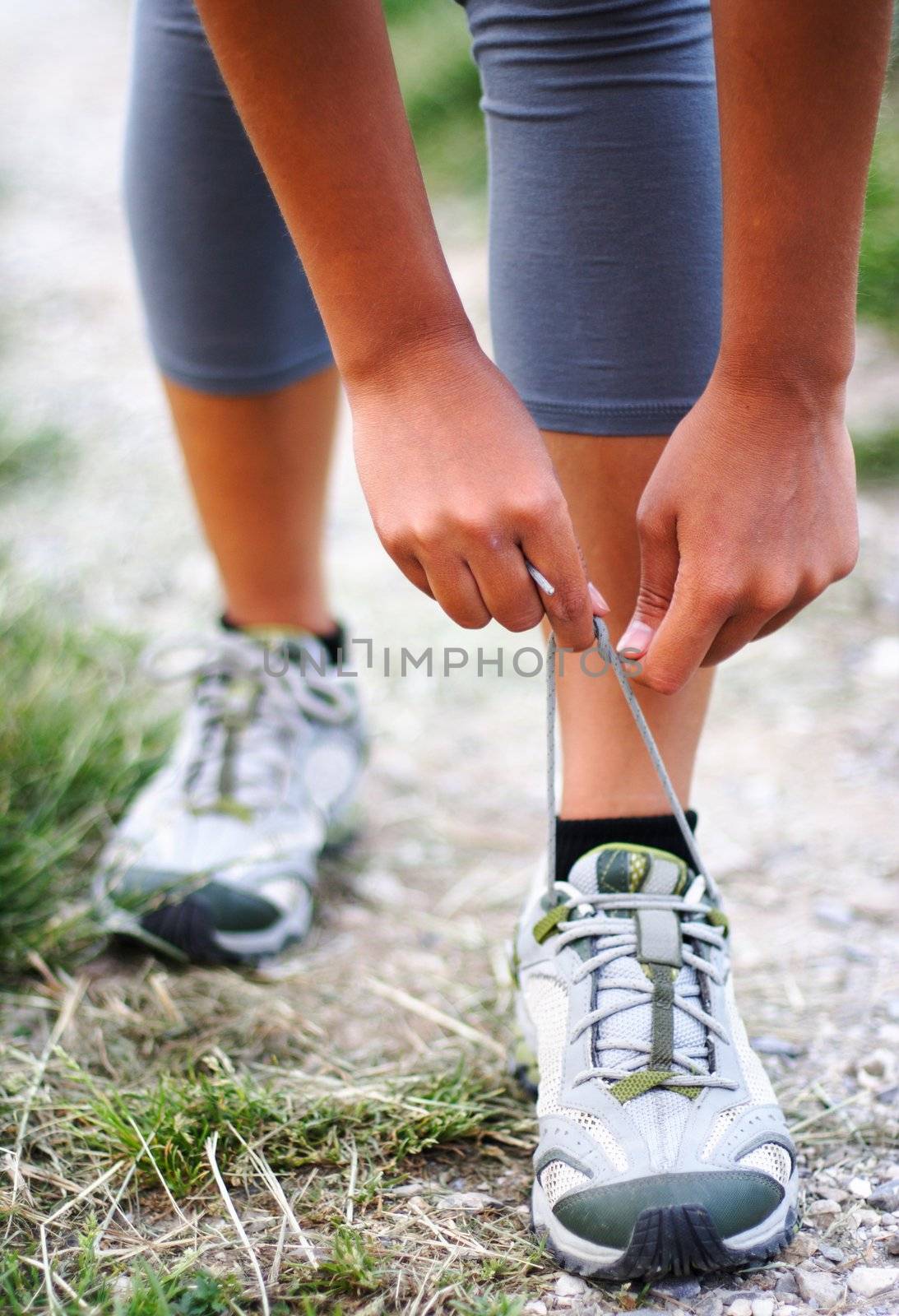 Running shoes being tied by woman getting ready for jogging.