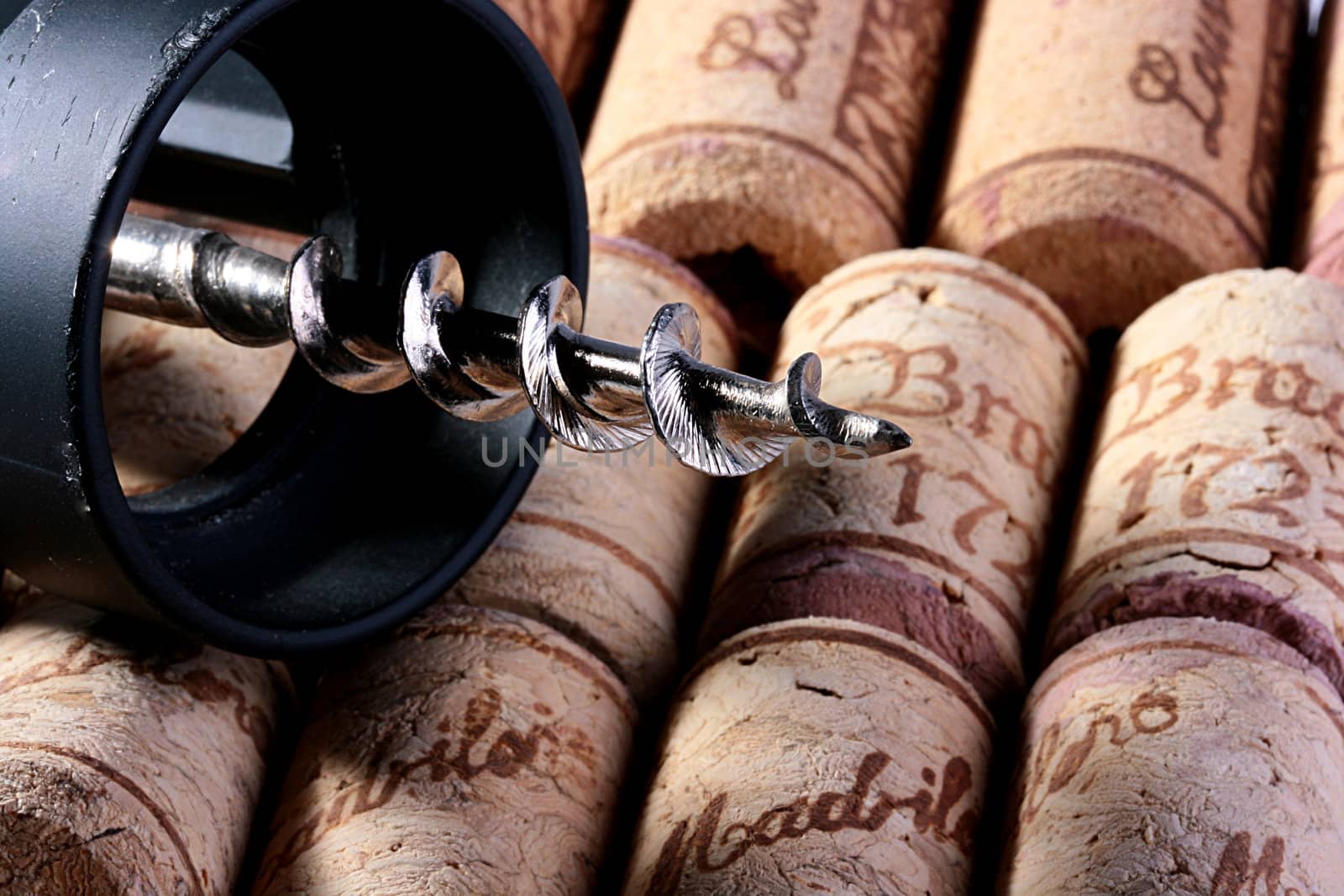Corkscrew and stoppers from wine bottles on a background.