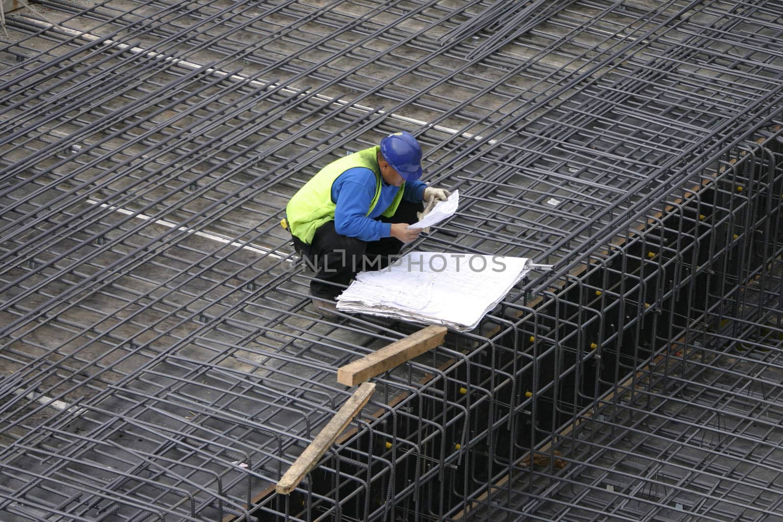 The site manager reads the building plans at a construction site.
