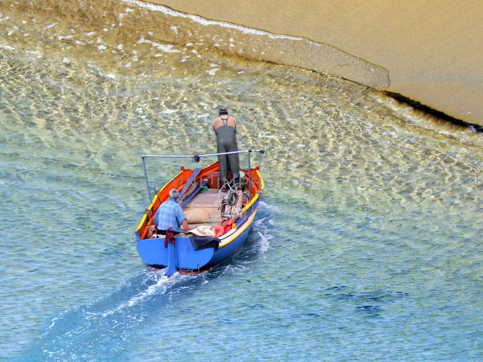 Surreal composite image of boat with fisherman next to gigantic sandy shore