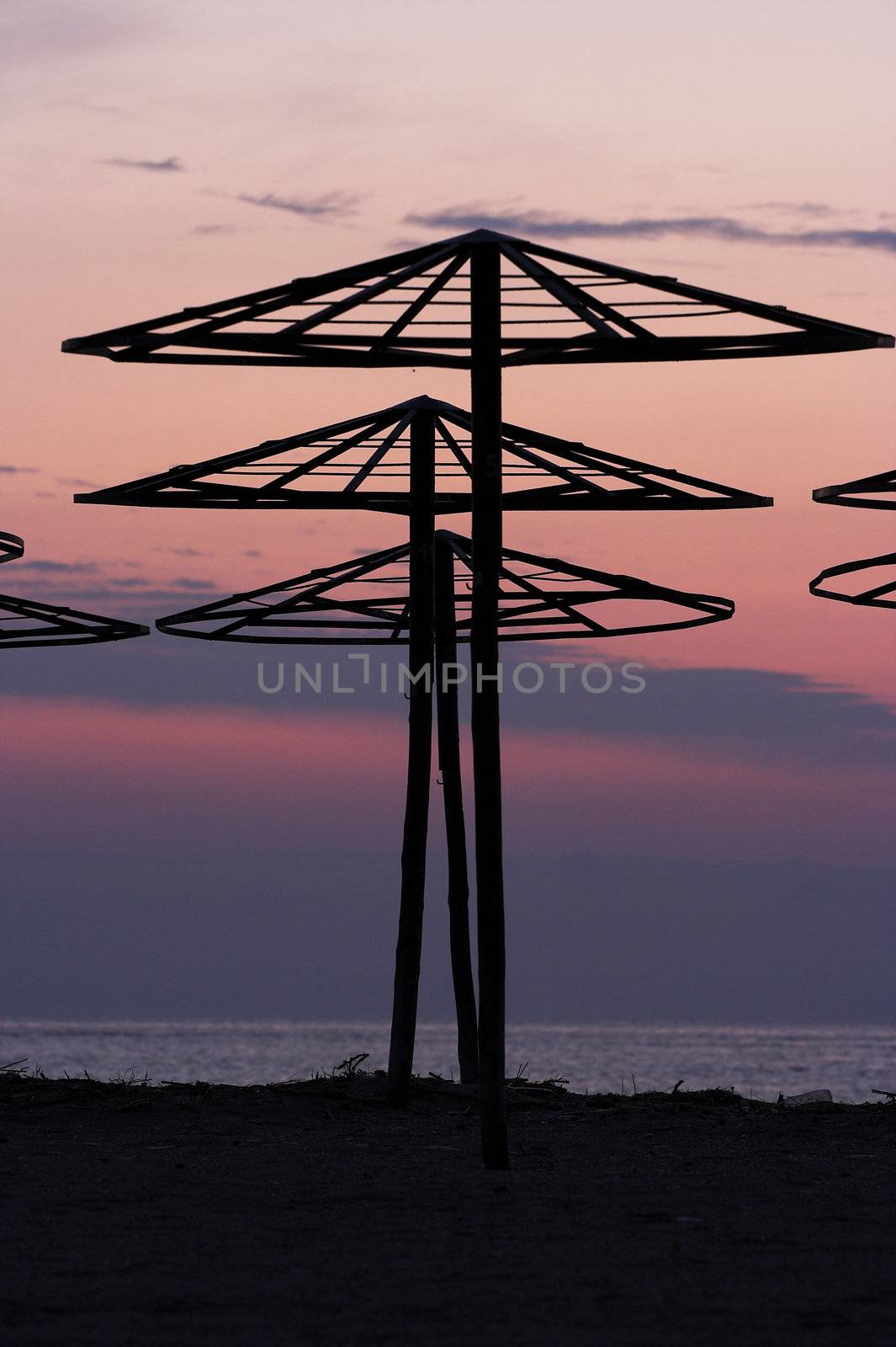 silhouettes of beach umbrellas at sunrise