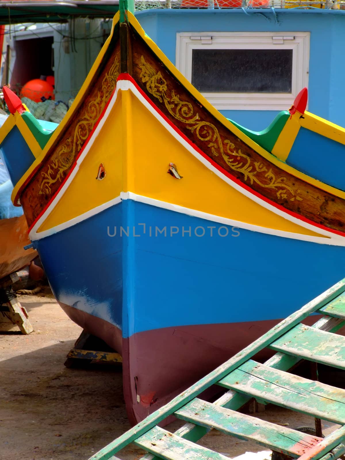 Traditional colors of the traditional Malta fishing boats, commonly known as luzzu or dghajsa. This one is attending repair on a quayside