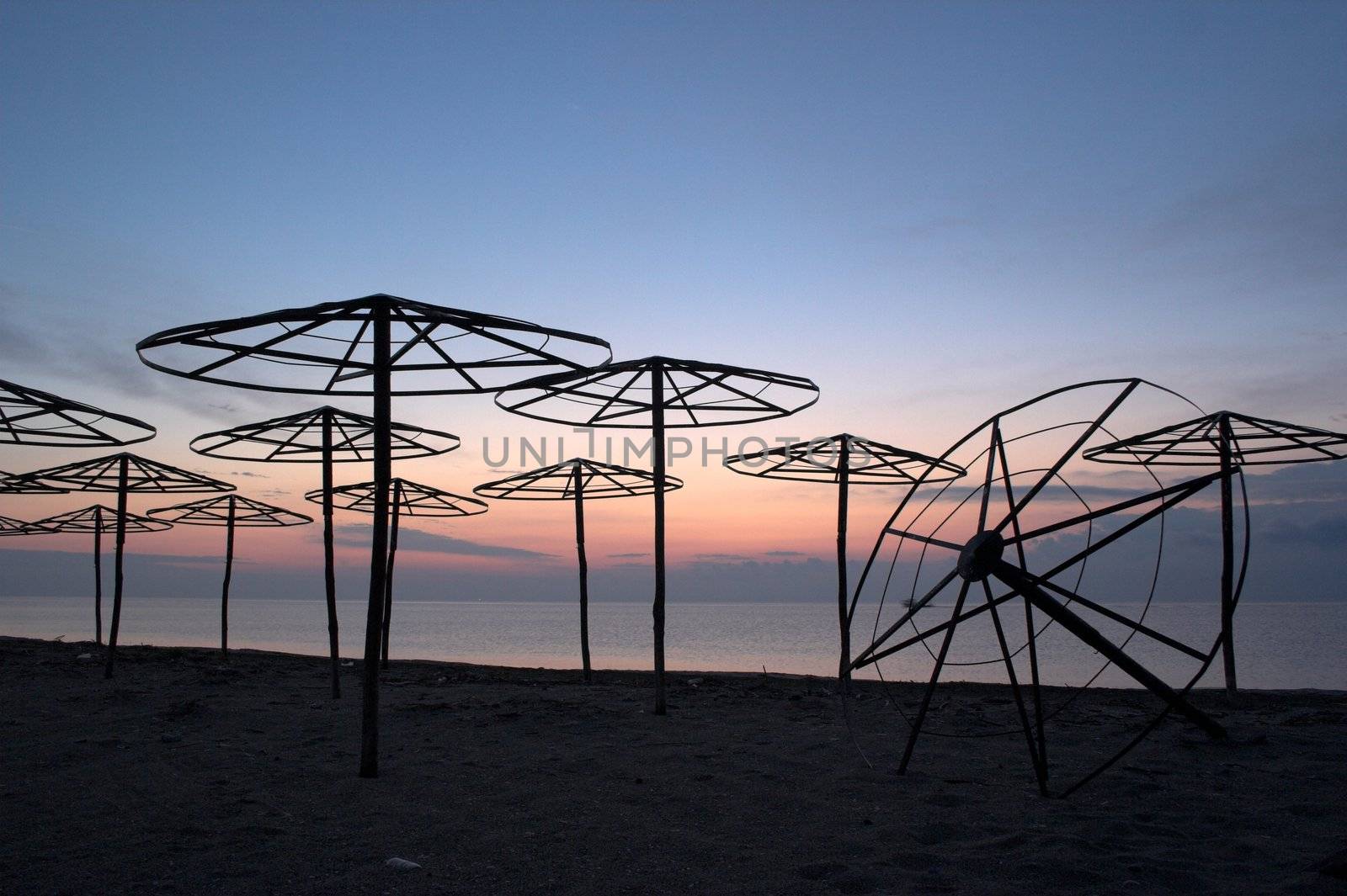 silhouettes of beach umbrellas at sunrise
