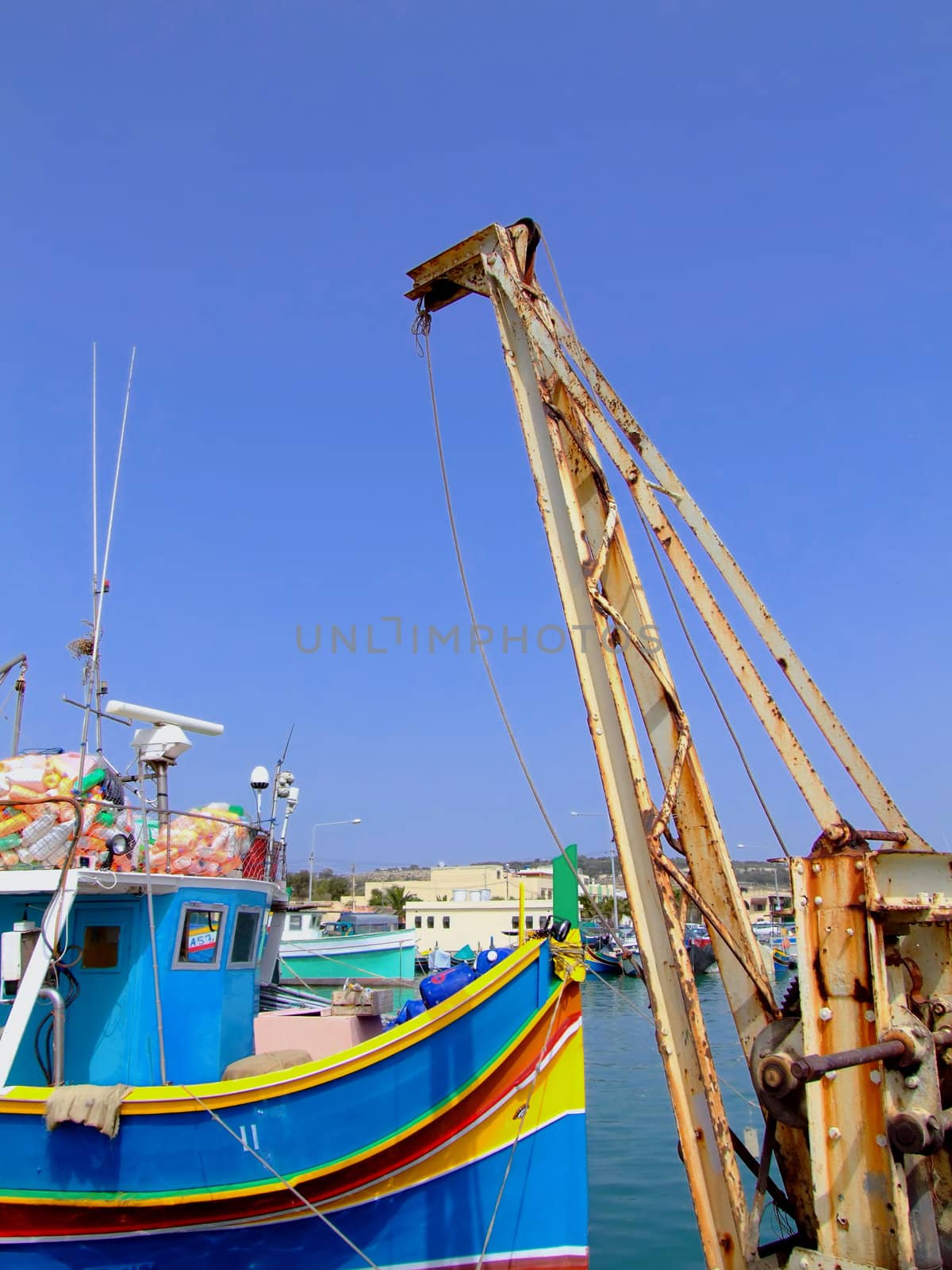 Trawler series - details of industrial fishing trawlers moored or out at sea. This one moored near hoist crane
