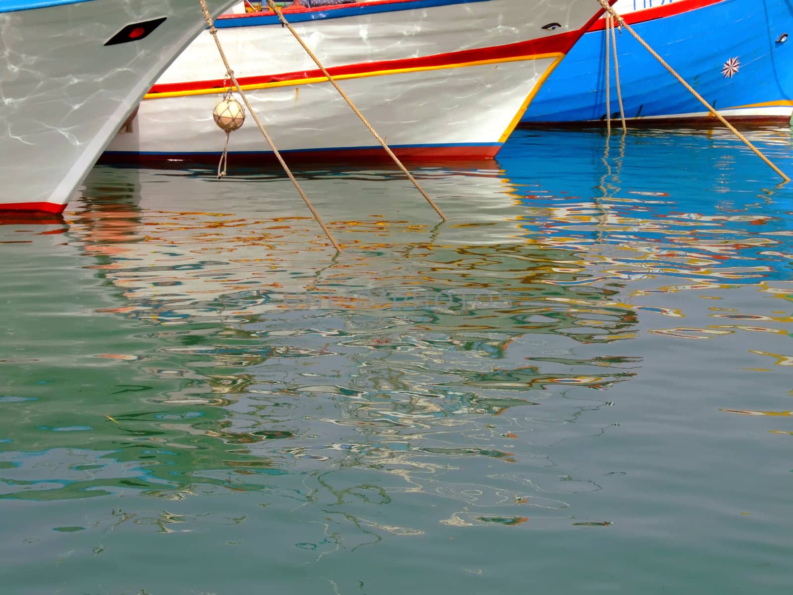 Moored yachts reflected in calm ocean waters, creating a soothing abstract effect