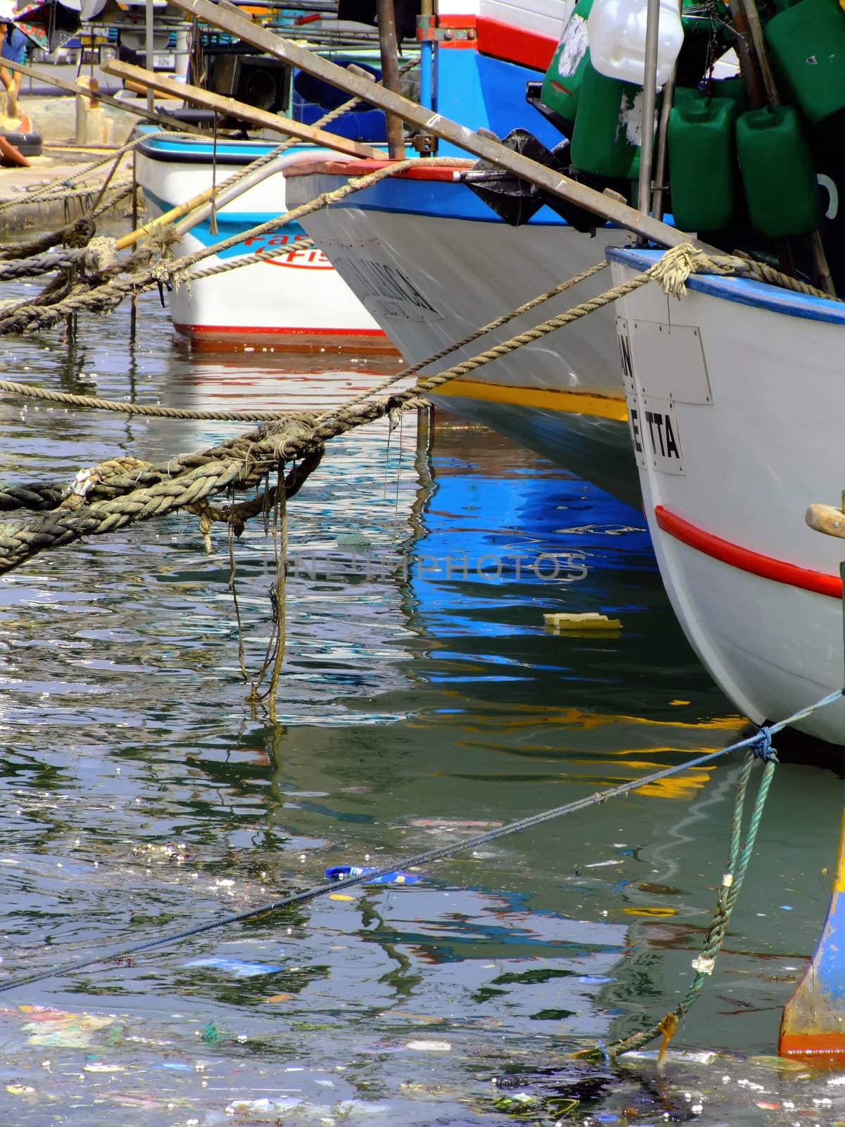 Moored yachts reflected in calm ocean waters, creating a soothing abstract effect