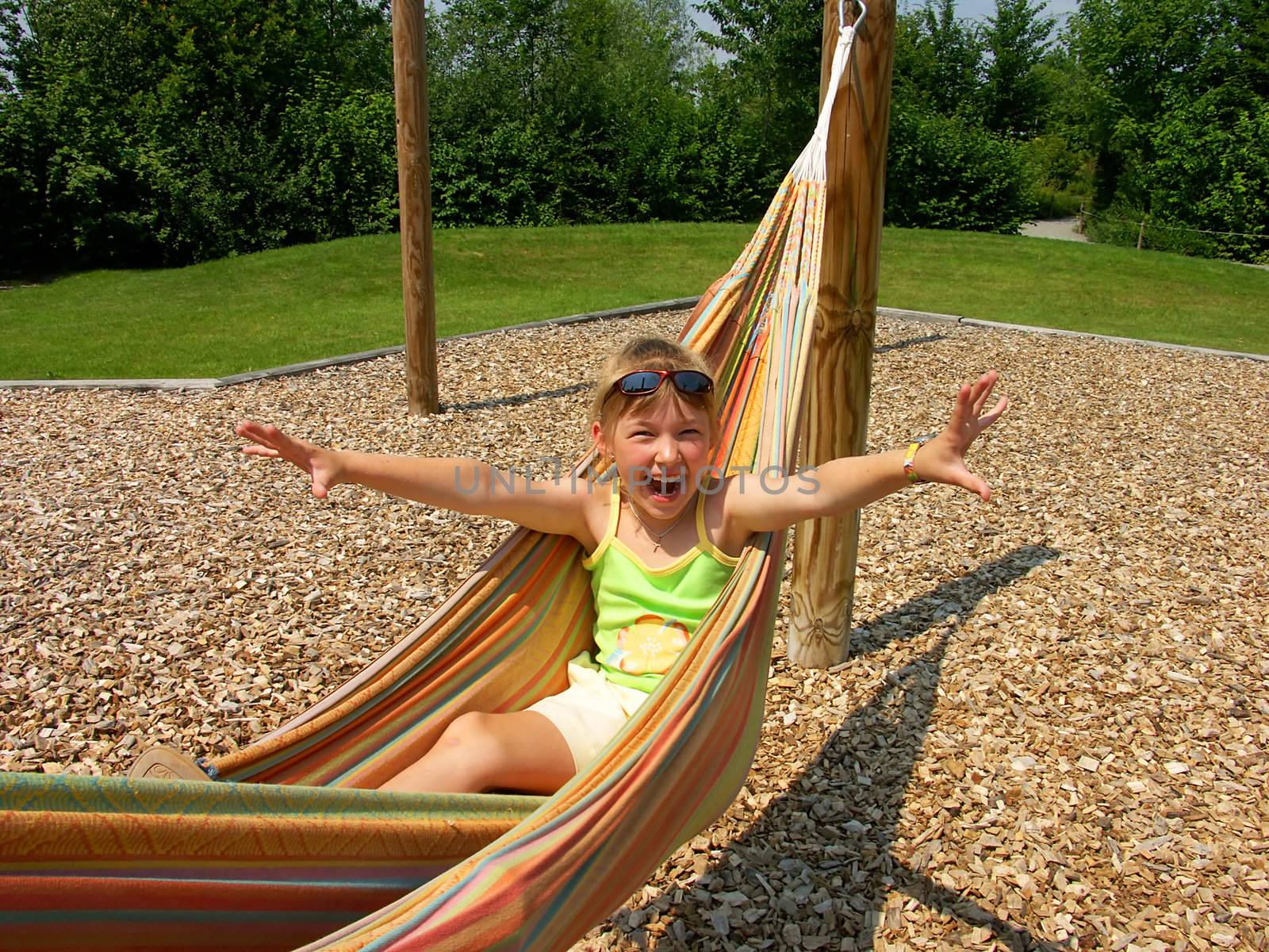 The joyful girl in a hammock. Germany.