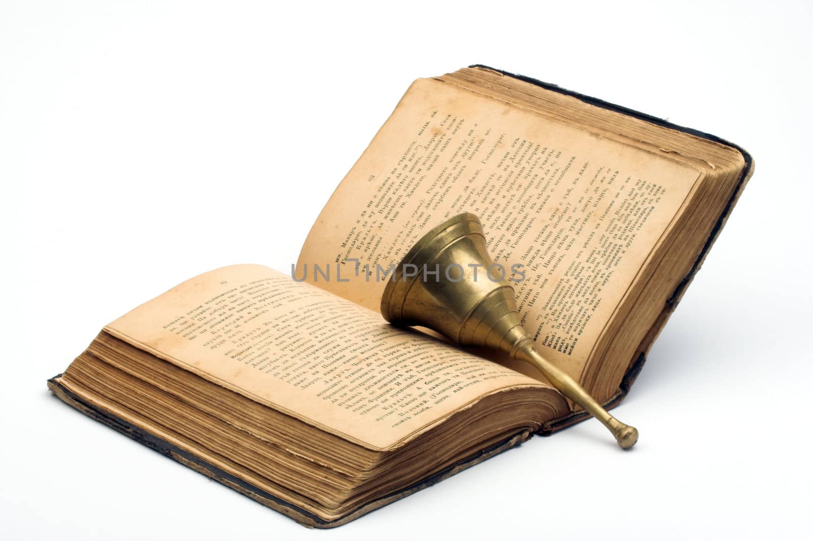 Old book and handbell over white