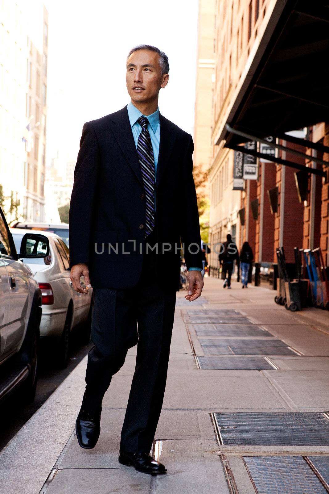 A business man in a city setting on a sidewalk