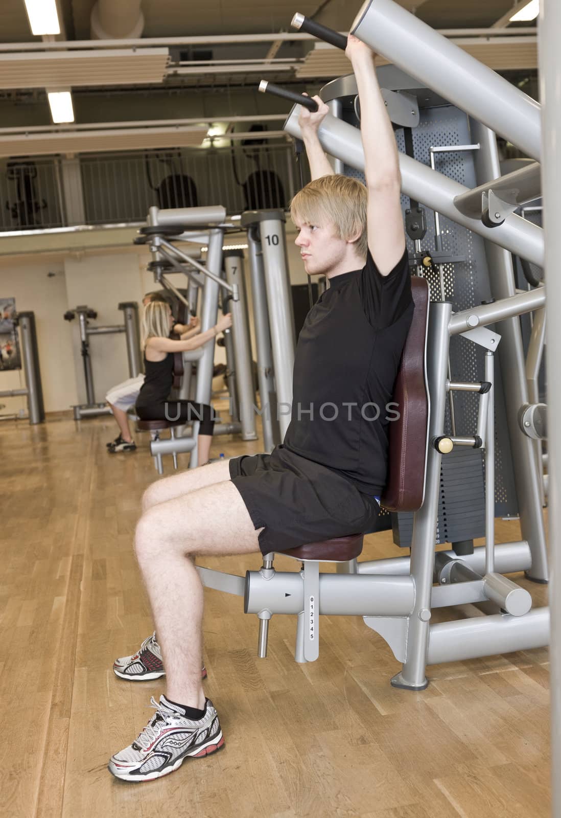 Young man using an exercise machine at a health club