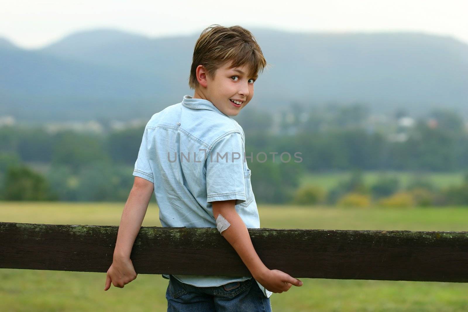 A young happy boy in the paddock on an overcast afternoon. f 3.5