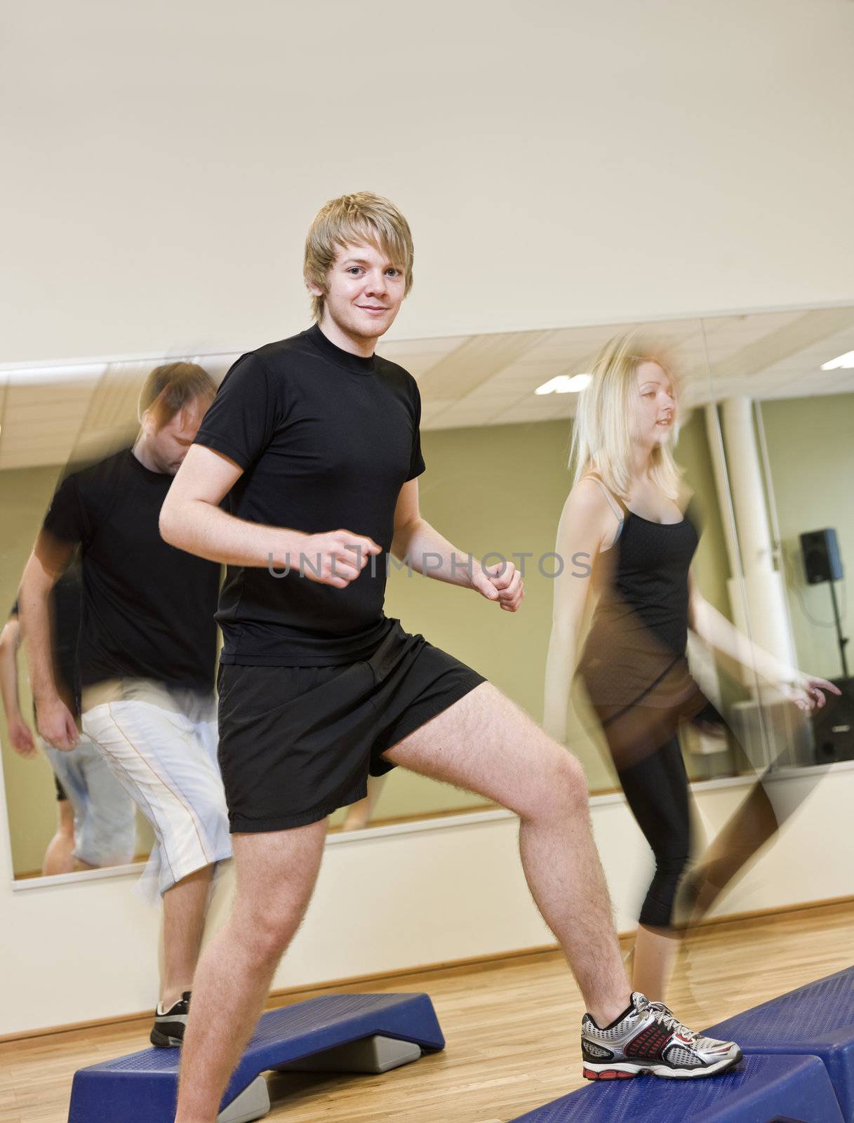 Group of people doing step up with a boy in focus